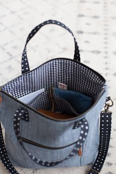 a purse sitting on top of a white floor next to a black and white polka dot bag