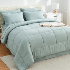 a bed with blue comforter and pillows in a room