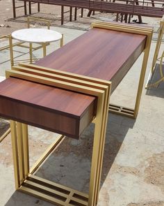 three tables with wooden top and metal legs in an outdoor setting, one has a small table on the other side