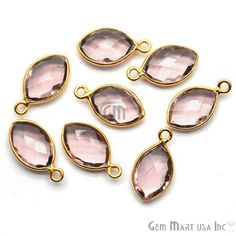 six pink glass tears with gold plated clasps on white background, set of five