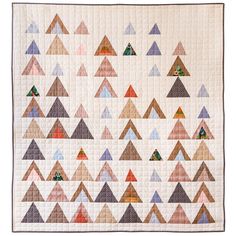 a quilted wall hanging with many different colored triangles