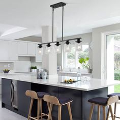 a kitchen with two stools next to an island