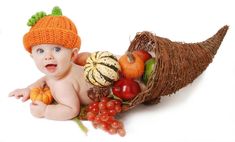 a baby wearing an orange knitted hat with pumpkins and gourds