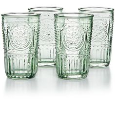 four green glass tumblers sitting next to each other