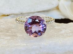 This beautiful solitaire setting contains a natural 3.8ct round Rose De France amethyst. The stone measures approximately 10mm. The band is 2mm wide and features beautiful beaded detailing. The ring is available in sterling silver, and 14k white, yellow, or rose gold. This ring makes a unique promise or engagement ring. Please send me a message if you need a size not listed. * This ring can be customized with any color center stone. All items are handmade by me in my shop in Woodbridge, NJ. Plea Luxury Round Crystal Ring With Amethyst, Round Amethyst Ring, Round Cut Topaz Ring With Gemstone Accents, Amethyst Ring With Round Center Stone, Amethyst Ring With Center Round Stone, Purple Amethyst Ring With Accent Stones, Sterling Silver Solitaire Amethyst Ring, Round Cut Solitaire Amethyst Birthstone Ring, Amethyst Solitaire Birthstone Ring, Round Cut