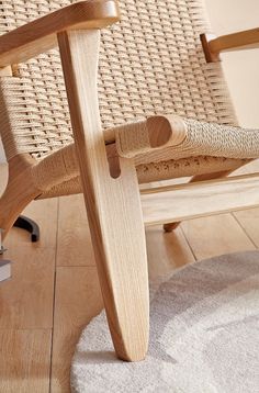 a wooden chair sitting on top of a hard wood floor next to a white rug