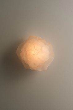 a light that is on the side of a wall with a white ceiling fixture in front of it