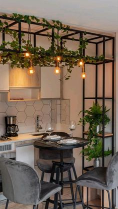 a kitchen with some chairs and a table in front of a stove top oven next to a potted plant