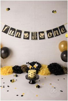 a birthday party with black and gold decorations, tissue pom poms and bums