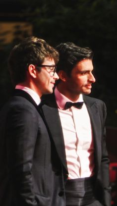 two men in tuxedos standing next to each other