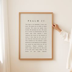 a woman standing in front of a framed poster