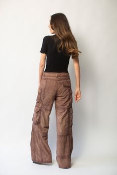 Deadwood's workwear-inspired cargo suede pants with wide flowing silhouette feature side pockets and multiple cargo pockets on the legs with a hidden push button closing. Made from upcycled deadstock goat suede Relaxed wide fit Zip fly Lining fabric from 100% recycled plastic bottles Brown Parachute Pants With Belt Loops For Fall, Brown Utility Parachute Pants, Brown Utility Parachute Pants Full Length, Brown Full-length Utility Parachute Pants, Brown Wide-leg Pants With Multiple Pockets, Brown Wide Leg Pants With Multiple Pockets, Leather Straight Leg Bottoms With Cargo Pockets, Brown Parachute Pants With Side Pockets For Fall, Brown Wide Leg Parachute Pants With Belt Loops