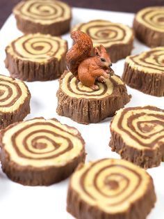 a pink rubber stamp sitting on top of wooden slices with a squirrel figurine next to it