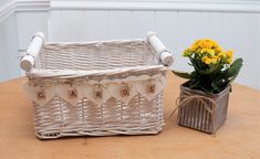 a wicker basket sitting on top of a wooden table next to a potted plant