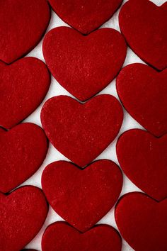 many red hearts are arranged on a white surface