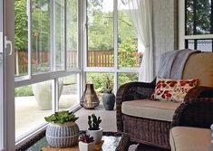 a living room filled with furniture next to a large glass window covered in white curtains