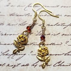 Rose Flower Dangle Earrings with Burgundy Faceted Glass Bead. Dangle approx 2".  Hypo-allergenic gold-tone ear wires. Adjustable Gold Rose Design Jewelry, Handmade Copper Gold Flower Earrings, Gold Nickel-free Drop Flower Earrings, Handmade Gold Flower Earrings In Copper, Gold Flower-shaped Copper Earrings, Gold Wire Wrapped Flower Earrings Gift, Adjustable Gold Flower Earrings, Gold Drop Earrings With Rose Design, Gold Dangle Flower Earrings With Hooks