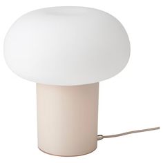 a white lamp sitting on top of a table next to a plugged in light