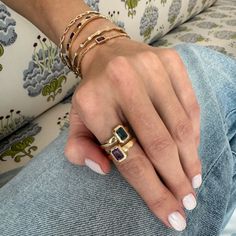 a woman's hand with three different rings on her fingers and two other bracelets