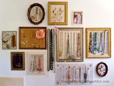 there are many framed pictures on the wall with jewelry hanging from it's sides