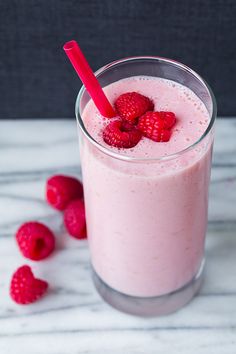 a smoothie with raspberries on the side