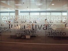 an office cubicle with glass walls and writing on it