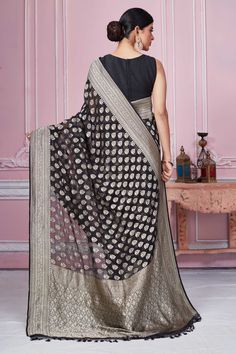 Beautiful black Banarasi saree with silver zari buta and border is a perfect choice for festive occasions. It comes with a matching blouse piece. Disclaimer: The shown stitched blouse on the model is for display purpose only. The saree comes with a matching blouse piece and finished with fall and piko. Black Art Silk Pre-draped Saree With Zari Weaving, Festive Black Pre-draped Saree With Self Design, Designer Art Silk Black Blouse Piece, Designer Black Art Silk Blouse Piece, Black Art Silk Blouse Piece For Eid, Black Art Silk Blouse Piece For Transitional Season, Traditional Silver Pre-draped Saree For Eid, Festive Black Pre-draped Saree With Cutdana, Elegant Black Saree For Transitional Season