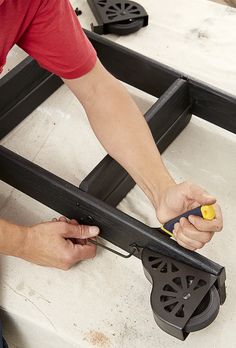 a man is working on a piece of furniture with a pair of scissors in his hand