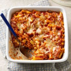 a casserole dish with meat, cheese and sauce in it on a blue checkered cloth