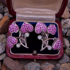 This fantastic pair of en tremblant earrings each feature three heart shaped cluster settings accented with seventy-three (73) round cut natural pink sapphires, and two (2) prong set round brilliant cut diamonds. The hearts settings are attached to springs that allow them to move. The earrings measure 28mm X 27mm and are finished with hinged backs for pierced ears. Pierced Ears, Round Brilliant Cut Diamond, Brilliant Cut Diamond, Heart Earrings, Pink Sapphire, Round Brilliant, Prong Setting, Ear Piercings, Round Cut