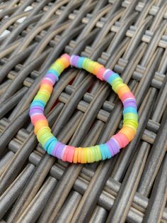 a multicolored bracelet sitting on top of a wicker table