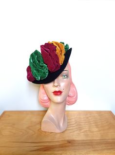 An elegant vintage 1940's tilt hat! Fashioned in soft black felt. Beautiful styling, featuring a small, tapered brim that is wired for shape. Styled with ruched velvet in jewel tones! The hat measures approx. 9 inches across at the widest point. The elastic band keeps the hat in place on the wearer. The interior is lined with a grosgrain band. Labeled Original Ruby Ross California. So divine!    Please note the color may vary depending on your monitor   Designed to fit most head sizes due to the Black Felt, Jewel Tones, Soft Black, Elastic Band, Accessories Hats, Ruby, Bathing Beauties, Accessory Gift, Felt