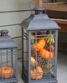 a lantern filled with pumpkins and pine cones