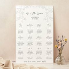 a wedding seating chart next to a vase with flowers