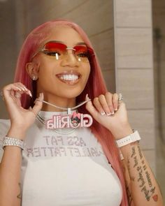 a woman with pink hair wearing sunglasses