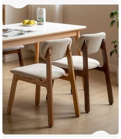 a dining table with two chairs and a plate of fruit on it