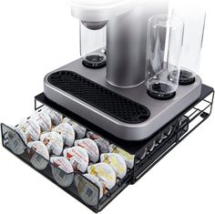 a silver coffee maker sitting on top of a metal tray filled with cups and saucers