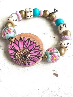 Pink Garden This pretty OOAK stretch bracelet was made with a beautiful hand painted wooden focal by AlisonPageStudios, artisan lampwork beads, African brass beads, bone beads, wooden beads, and strong stretch cord.  It should fit most wrist sizes.  My wrist measures 6 3/4" and it fits comfortably. Bohemian Flower Stretch Bracelet Gift, Bohemian Flower Stretch Bracelet As Gift, Adjustable Hand Painted Pink Jewelry, Pink Adjustable Hand Painted Jewelry, Blue Flower Bracelet, Lover Bracelet, African Brass Beads, Lovers Bracelet, Bead Projects