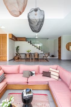 a living room filled with lots of pink couches and pillows on top of a rug