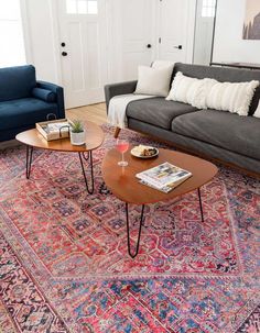 a living room with two couches, a coffee table and a rug on the floor