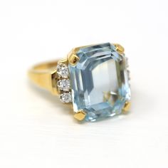 Stunning estate 14k yellow gold genuine aquamarine & diamond ring! This gorgeous statement ring features an emerald cut 16.07 carat genuine aquamarine with amazing saturation. There are three accent diamonds on each shoulder. A fabulous piece of fine modern jewelry, featuring March's birthstone! ERA - Modern, Estate METAL / MATERIAL - 14k yellow gold, genuine aquamarine (approx. 16.07 CT), 6 genuine diamonds (approx. .24 CTW, VS clarity, near colorless) MARKINGS / HISTORY - Inside of shank is st Formal Light Blue Diamond Ring, Aquamarine Brilliant Cut Diamond Ring For Formal Occasions, Formal Aquamarine Diamond Ring With Brilliant Cut, Formal Light Blue Aquamarine Diamond Ring, Formal Aquamarine Ring With Diamond Accents, Formal Aquamarine Diamond Ring With Prong Setting, Formal Light Blue Diamond Ring With Center Stone, Classic Light Blue Diamond Ring, Classic Light Blue Brilliant Cut Jewelry