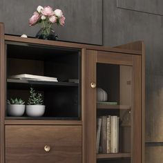 a wooden cabinet with glass doors and flowers on top