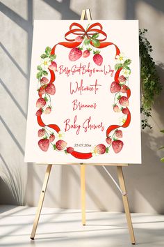 a white sign with strawberries on it and a red ribbon around the frame that says,