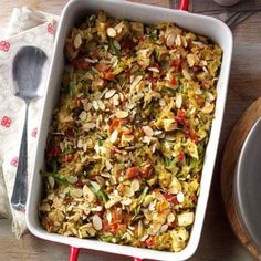 a casserole dish filled with lots of food on top of a wooden table