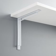 a white shelf mounted to the side of a wall