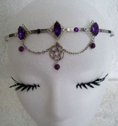 This beautiful circlet has three sterling silver plated filigree accents with purple faceted glass settings, purple faceted bead drops, rhinestones, pewter silver pentacle and metal chain. Adjustable. Silver Adjustable Headband For Festivals, Purple Metal Jewelry For Halloween, Elegant Adjustable Jewelry For Cosplay, Adjustable Fantasy Jewelry For Festivals, Adjustable Fantasy Festival Jewelry, Silver Gothic Headpiece For Festivals, Silver Fantasy Costume Jewelry, Gothic Adjustable Body Jewelry For Festivals, Fantasy Metal Body Jewelry For Festival