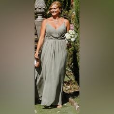 a woman in a long gray dress is walking