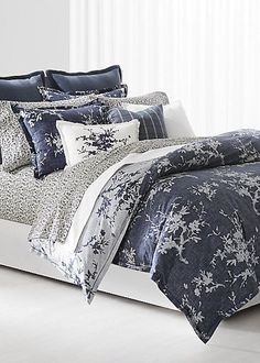 a bed covered in blue and white comforters