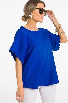 Bold color and scalloped sleeves... OH MY! This top is beyond cute. It's made from a smooth woven fabric with a back button closure, so you can dress it up or down! Summer Top With Scalloped Edges For Day Out, Cotton Short Sleeve Tops With Scalloped Edges, Cotton Tops With Scalloped Edges And Short Sleeves, Short Sleeve Cotton Tops With Scalloped Edges, Chic Tops With Scalloped Edges For Day Out, Summer Cotton Tops With Scalloped Edges, Spring Cotton Top With Scalloped Edges, Spring Short Sleeve Tops With Scalloped Edges, Cotton Tops With Scalloped Edges For Spring