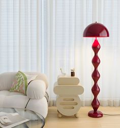 a living room with a white couch and a red lamp on top of the table